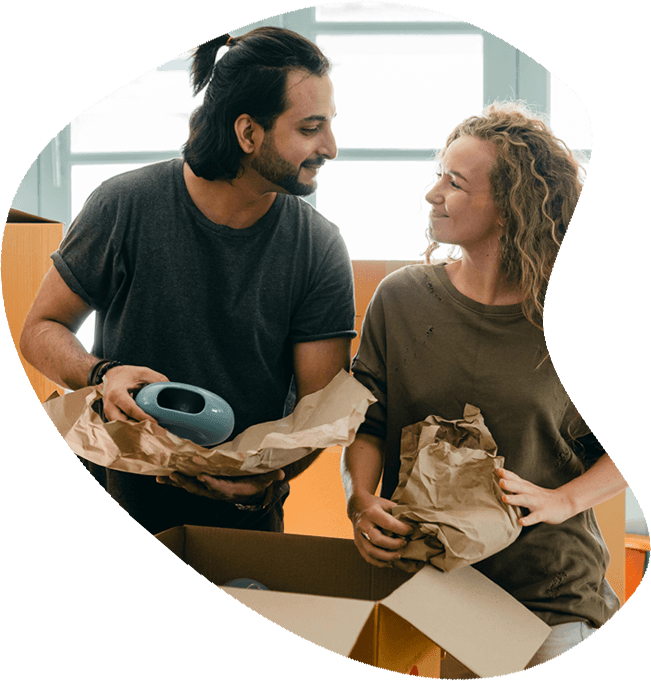 a man and woman unpacking moving boxes while smiling at each other